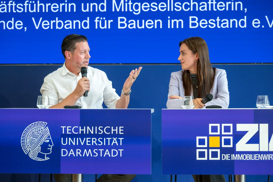 Zwei diskutierende Personen zum Thema „Deutschland im Umsetzungsstau – Was Politik und Unternehmen ausbremst und wie Standorte wieder Tempo aufnehmen“