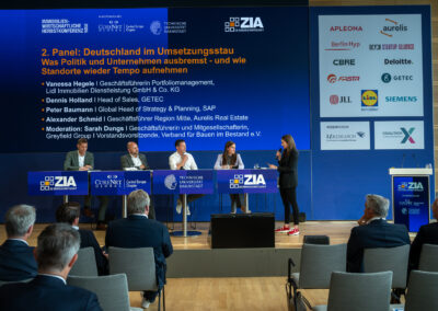 Das Panel „Deutschland im Umsetzungsstau – Was Politik und Unternehmen ausbremst und wie Standorte wieder Tempo aufnehmen“ mit Vanessa Hegele (Lidl Immobilien), Dennis Holland (GETEC Group) Peter Baumann, MCR (SAP) Alexander Schmid (Aurelis Real Estate) und Sarah Dungs (Greyfield Group; Verband für Bauen im Bestand (BiB) e. V.)